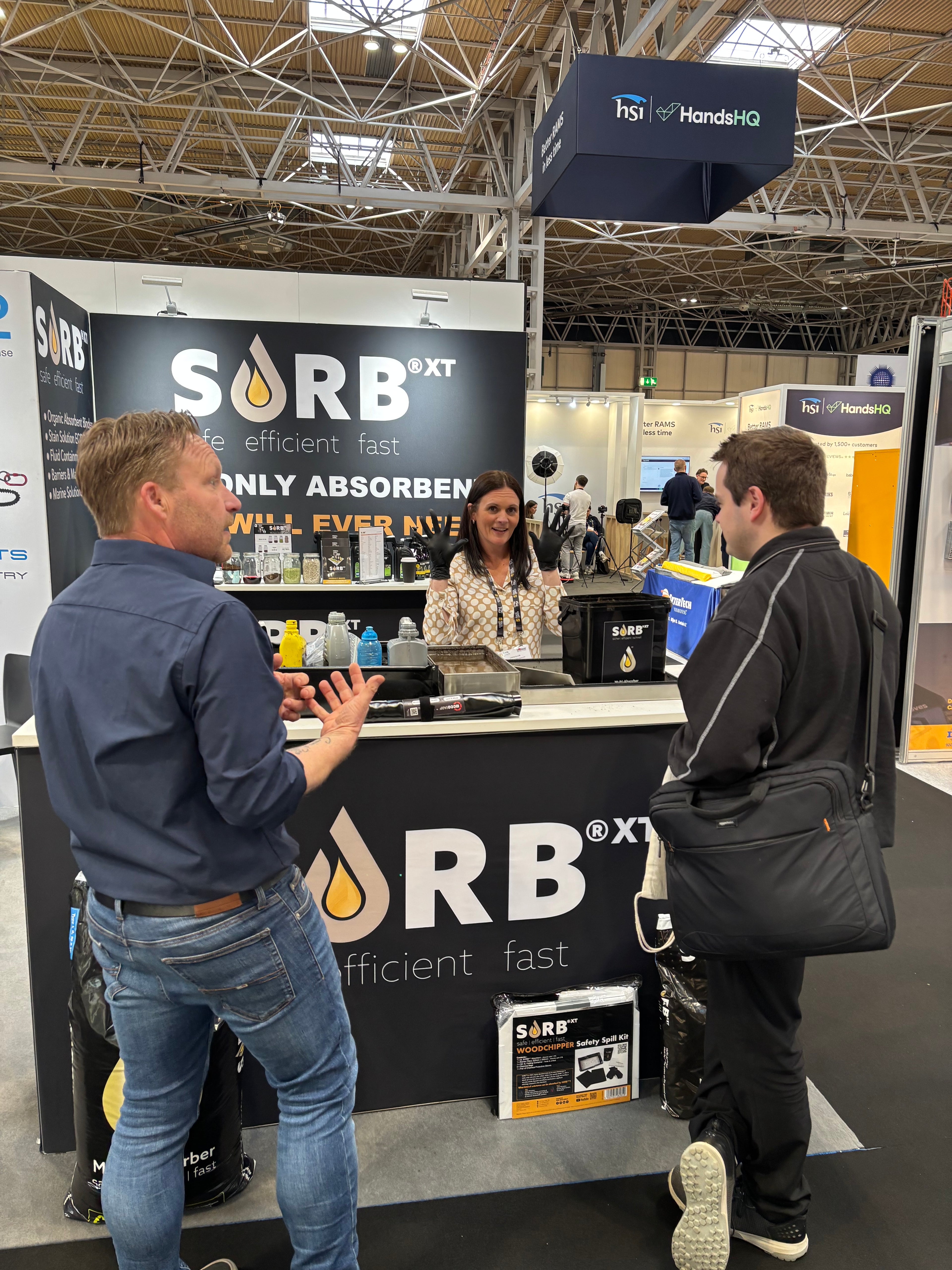 Two men interacting at a SORB booth during an event with various products on display.